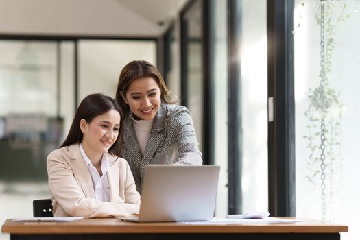 Two young Asian businesswoman discuss financial management planning. new startup project ideas analysis of financial planning and statistics and the investment market at the office..