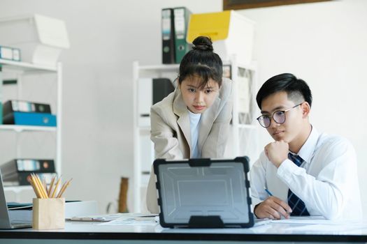 Businesspeople or colleagues are working together on project, discussing, sharing ideas, planning, and analyzing the business strategy and finance using laptop computer.