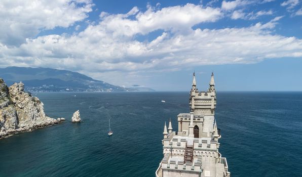 Aerial view of Swallow's Nest castle on the rock in Black Sea. It is a symbol and landmark of Crimea. Beautiful scenic panorama of the Crimea coast. Amazing Swallow's Nest at the precipice.