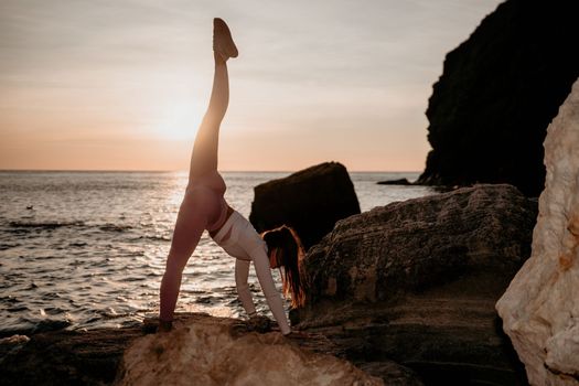 Young woman with black hair, fitness instructor in pink sports leggings and tops, doing pilates on yoga mat with magic pilates ring by the sea on the beach. Female fitness daily yoga concept