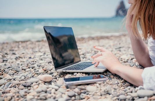 Woman sea laptop. Business woman in yellow hat working on laptop by sea. Close up on hands of pretty lady typing on computer outdoors summer day. Freelance, digital nomad, travel and holidays concept