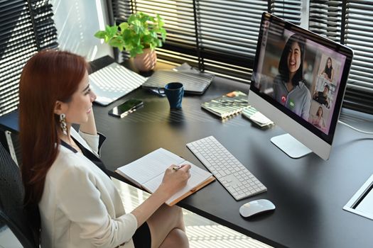 Millennial female manager communicating by video conference on computer. Distant webinar, online negotiations concept.