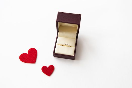 Beautiful red hearts on a white background together with a ring in a box. Marriage proposals