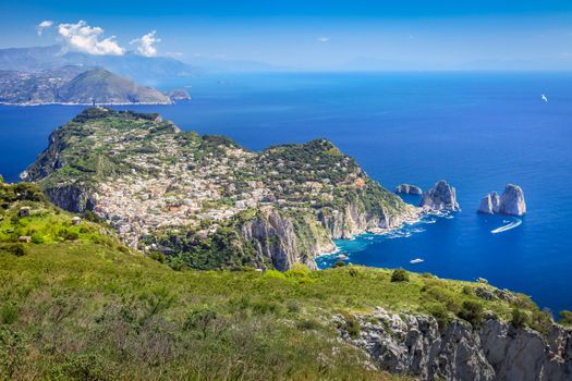 Idyllic aerial view of Capri island city and Faraglioni cliffs and marina with boats and yacht, amalfi coast, Italy