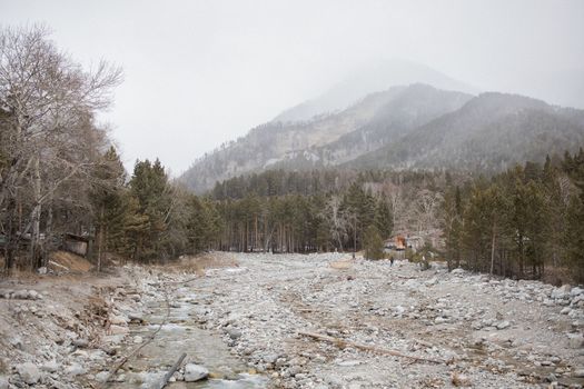 Mirror reflection of Khurai-hobok village in the dense fog against the background of the Sayan Mountains