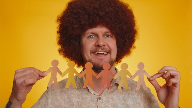 Bearded man showing multiracial different skin color human shape cut out of paper, concept of teamwork, partnership, community, unity, people support love, against racism. Hipster guy, afro hairstyle