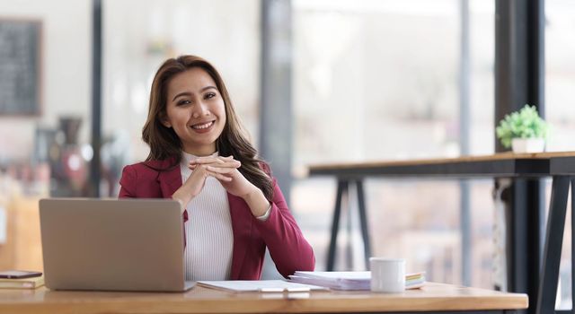 Attractive young asian woman using laptop computer while standing in a office...