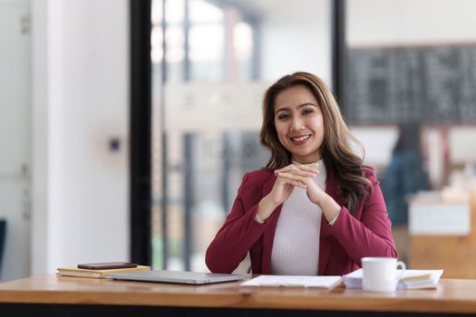 Attractive young asian woman using laptop computer while standing in a office...