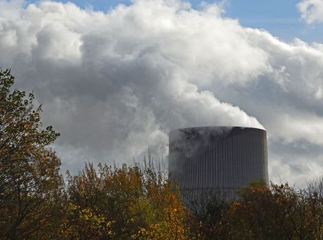 Working cooling tower of a nuclear power plant in Germany. A smoke stack is creating clouds