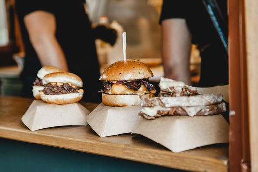 Burgers at a burger feast. Dinner Hamburger Food Feast Party. Big burger at street food outdoor festival. Festival food day.