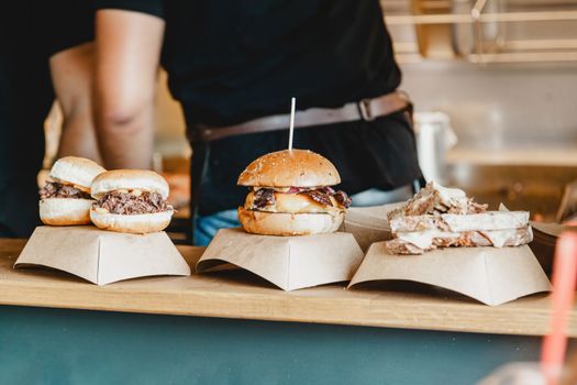 Burgers at a burger feast. Dinner Hamburger Food Feast Party. Big burger at street food outdoor festival. Festival food day.