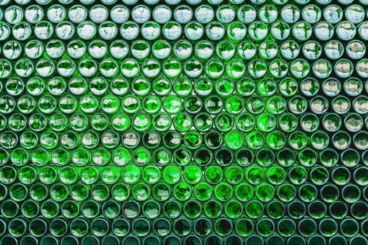Glass bottles green. Green glass bottles of beer. Wall formed by green bottles. Green bottles background. Empty Glass Bottle with Lighting.