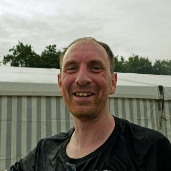 Portrait of a man who has just run. His face is flushed and he is happy with his achievement.