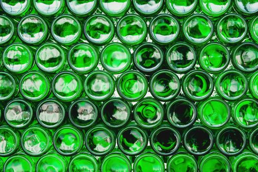 Glass bottles green. Green glass bottles of beer. Wall formed by green bottles. Green bottles background. Empty Glass Bottle with Lighting.