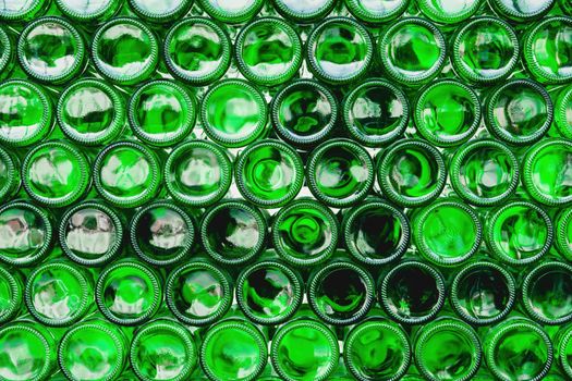 Glass bottles green. Green glass bottles of beer. Wall formed by green bottles. Green bottles background. Empty Glass Bottle with Lighting.