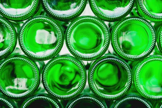 Glass bottles green. Green glass bottles of beer. Wall formed by green bottles. Green bottles background. Empty Glass Bottle with Lighting.