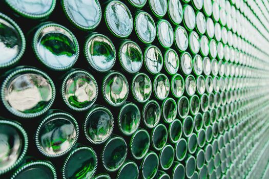 Glass bottles green. Green glass bottles of beer. Wall formed by green bottles. Green bottles background. Empty Glass Bottle with Lighting.