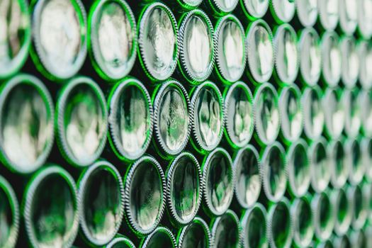 Glass bottles green. Green glass bottles of beer. Wall formed by green bottles. Green bottles background. Empty Glass Bottle with Lighting.