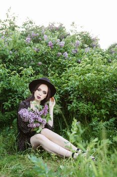 A fashionable girl with dark hair, a spring portrait in lilac tones in summer. Bright professional makeup