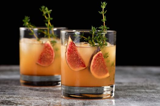 Bourbon Sour cocktail with fig spices, lemon juice and syrup. Easy to make but so delicious. Garnish with figs and thyme.