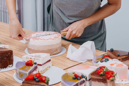 Cutting a chocolate mousse cake on the table. Preparation of mousse cakes at a culinary master class. Cooking at home, homemade food.