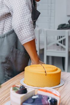 Cutting a chocolate mousse cake on the table. Preparation of mousse cakes at a culinary master class. Cooking at home, homemade food.