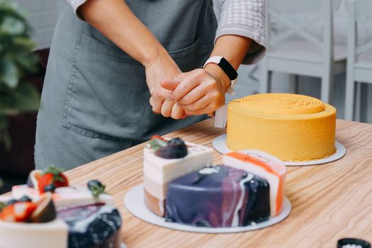 Cutting a chocolate mousse cake on the table. Preparation of mousse cakes at a culinary master class. Cooking at home, homemade food.