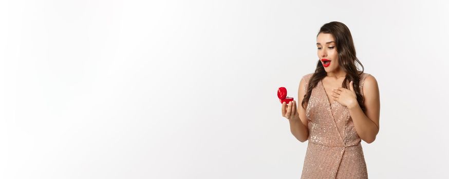 Image of surprised woman receiving marriage proposal, looking at engagement ring in red box and gasping amazed, concept of relationship.