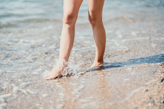 Barefoot woman standing in sea, summer vacation on beach resort. Naked female legs in transparent calm water
