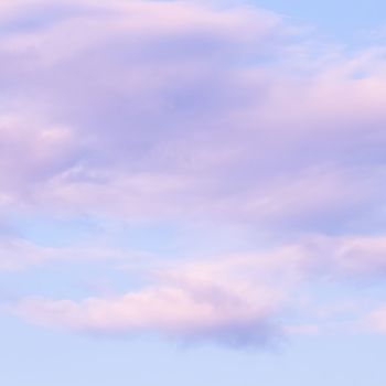 Blue sky background with white and pink clouds at sunset. High quality photo