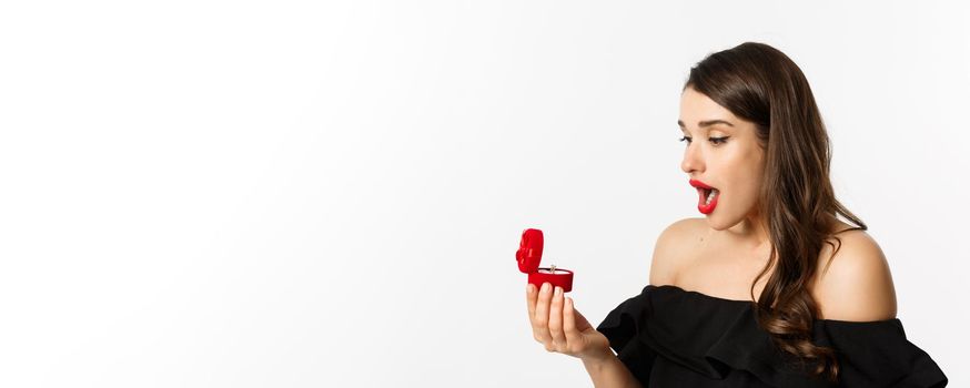 Close-up of surprised woman open box with engagement ring, looking amazed, receiving marriage proposal, girlfriend getting married.