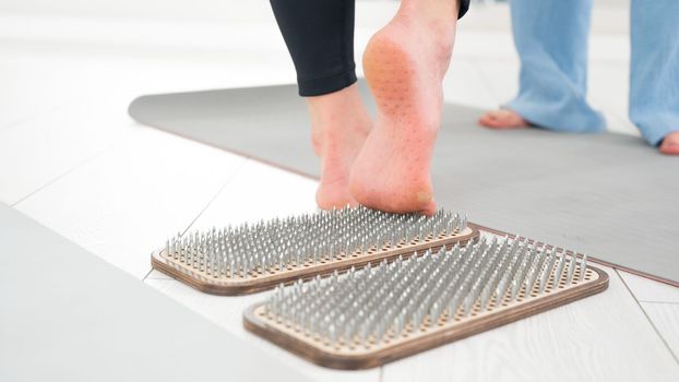 A woman comes down from the sadhu boards. Close-up of feet with prints after nails