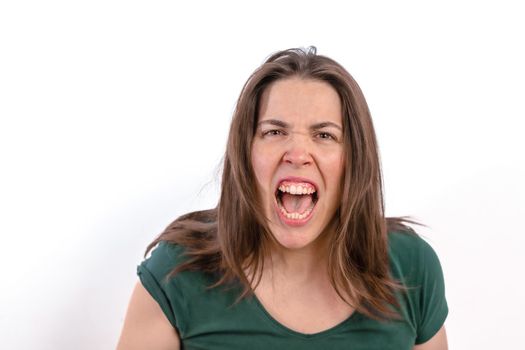 close-up of a furious woman looking at the camera with her teeth showing on a white background