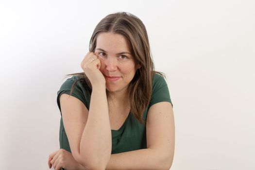 close-up of an attractive young woman looking at the camera smiling on a white background