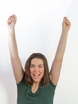 close-up of woman with raised arms symbolizing victory smiling with white background