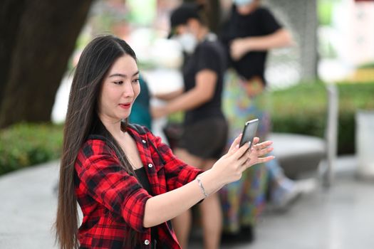 Young Asian woman using smart phone and holding credit card for shopping online.