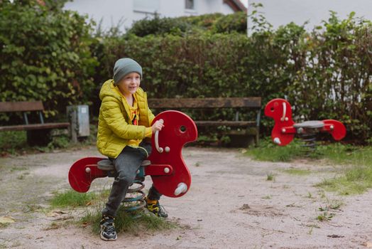 Funny cute happy baby playing on the playground. The emotion of happiness, fun, joy. Smile of a child. boy playing on the playground.