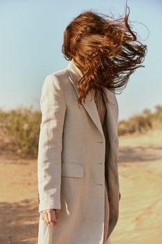 a strong wind inflates a woman with red, long hair. High quality photo