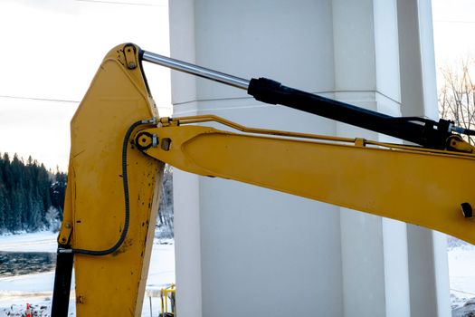 A close up to a cylinders hydraulic excavator during the winter.