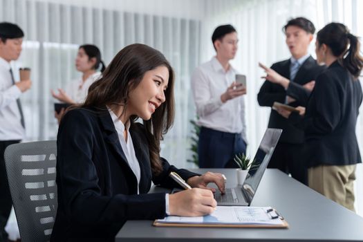 Focus portrait of female manger, businesswoman in the harmony meeting room with blurred of colleagues working together, analyzing financial paper report and dashboard data in background.