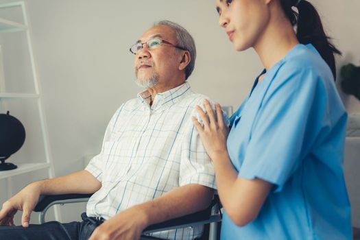 Caring nurse and a contented senior man in a wheel chair at home, nursing house. Medical for elderly patient, home care for pensioners.