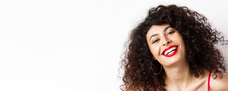Close-up portrait of happy beautiful woman with curly hair and red lip, smiling white teeth, express happiness and joy.