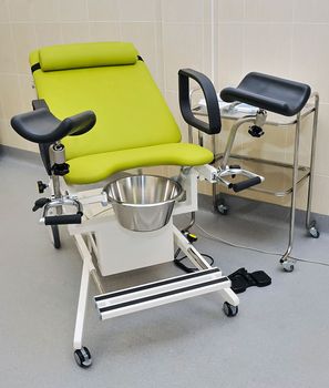 the gynecological chair in the doctor's examination room is green without people.