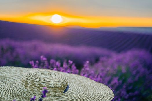 Close-up of a hat on lavender flowers on a sunset background. Love in the lavender concept.