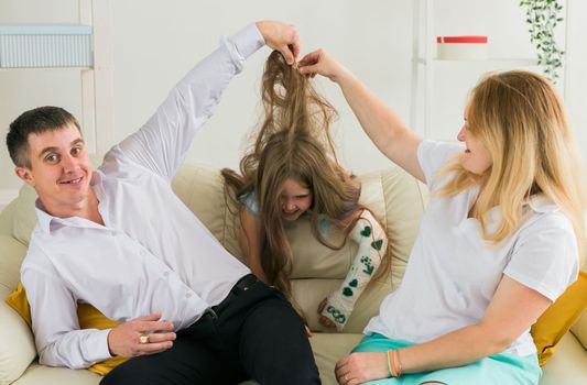 Family sitting on sofa in their living room. Daughter have injury hand but she is happy be together her family