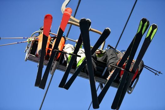 Skiers climb the cable car with skis in the mountains