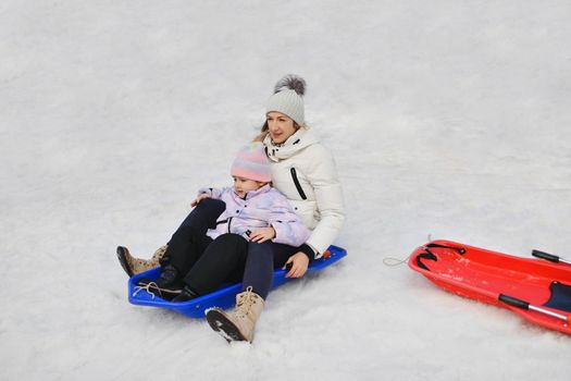 The mother with child sledding in the snow