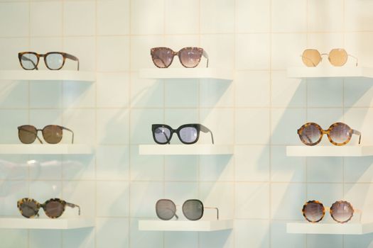 Exhibitor of glasses consisting of shelves of fashionable glasses shown on a wall at the optical shop