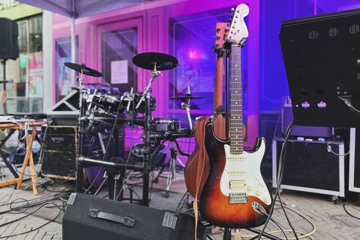 Electric guitar with wires stands on a stage