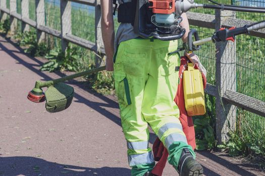 Lawn mower in a uniform with equipment